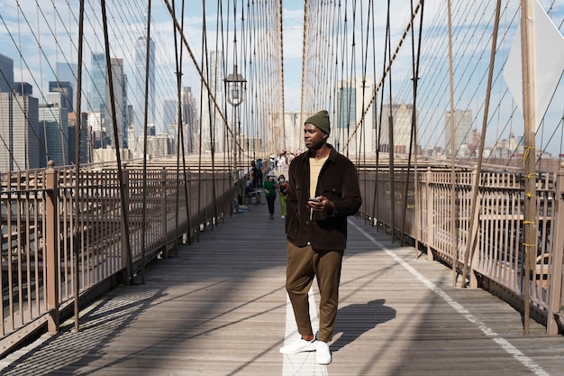 Joven elegante explorando un puente de la ciudad por sí mismo