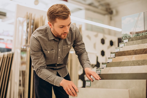 Foto gratuita joven eligiendo azulejos en el mercado de la construcción