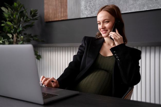 Foto gratuita joven embarazada en el trabajo