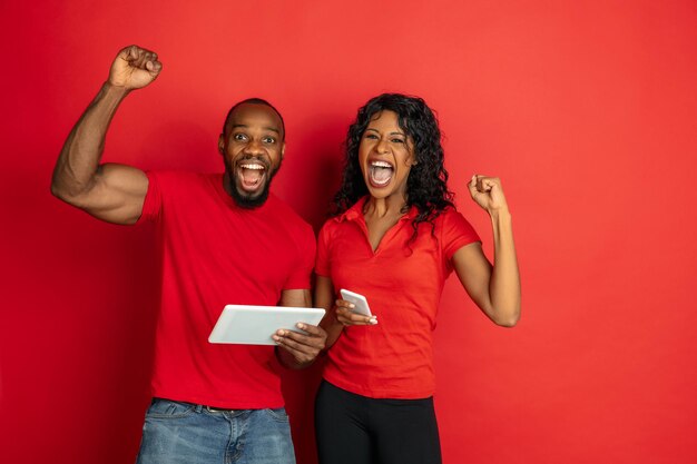 Joven emocional afroamericano y mujer en rojo