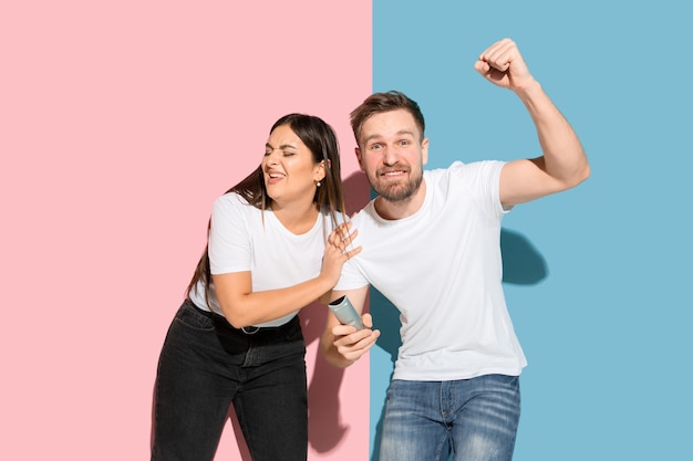 Foto gratuita joven emocional y mujer en pared rosa y azul