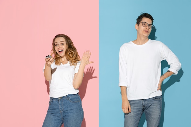 Joven emocional y mujer en rosa y azul