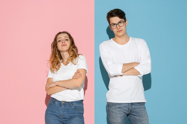 Joven emocional y mujer en rosa y azul