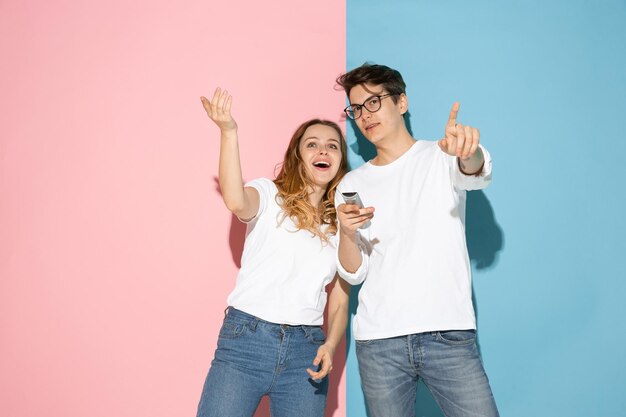 Joven emocional y mujer en rosa y azul