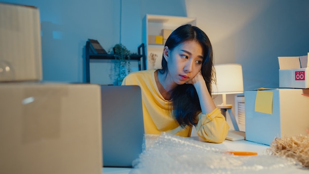 Joven empresaria asiática estresada y molesta con mala venta en la oficina en casa por la noche