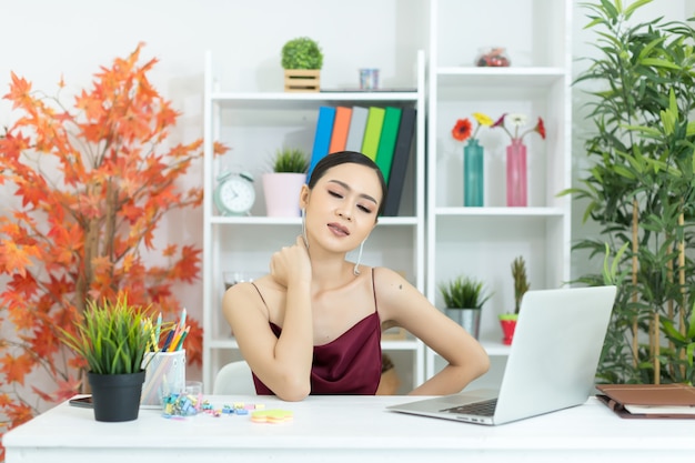 Foto gratuita joven empresaria asiática tocando masaje cuello rígido