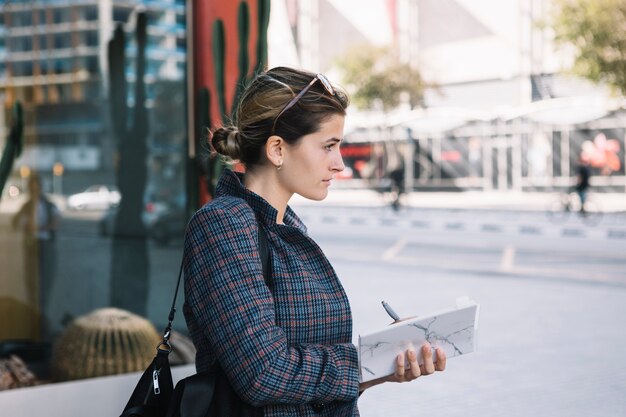 Joven empresaria con diario y pluma