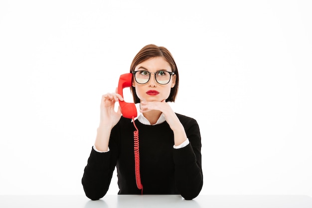 Foto gratuita joven empresaria hablando por teléfono levantando una ceja