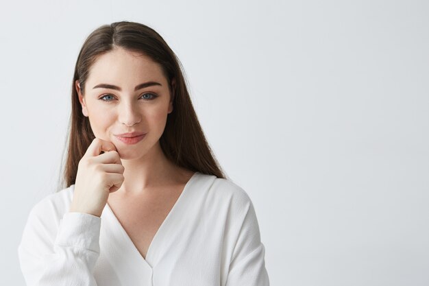 Joven empresaria juguetona hermosa con astuta mirada difícil sonriendo.