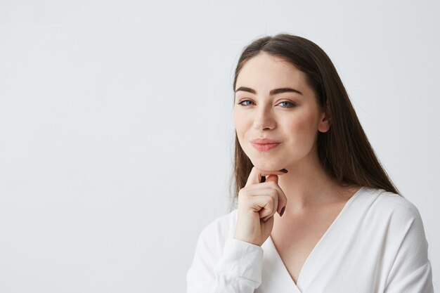 Joven empresaria juguetona hermosa con astuta mirada difícil sonriendo.