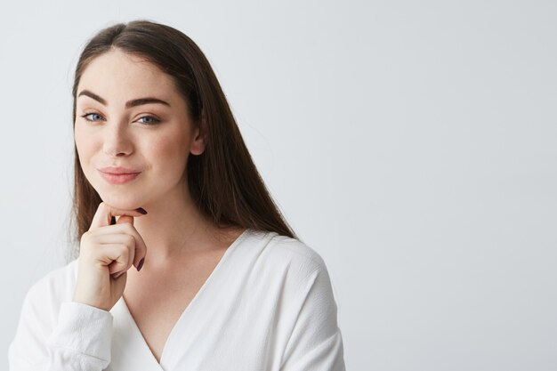 Joven empresaria juguetona hermosa con astuta mirada difícil sonriendo.