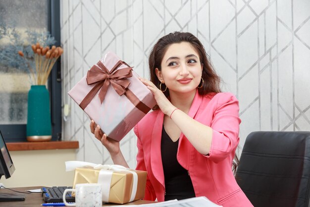 Joven empresaria sosteniendo una caja de regalo Foto de alta calidad