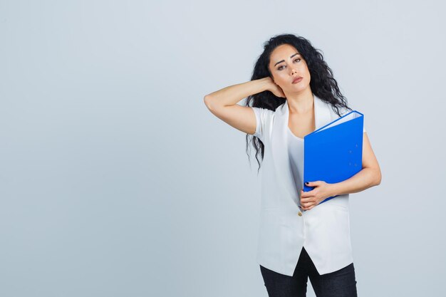 Joven empresaria sosteniendo una carpeta azul