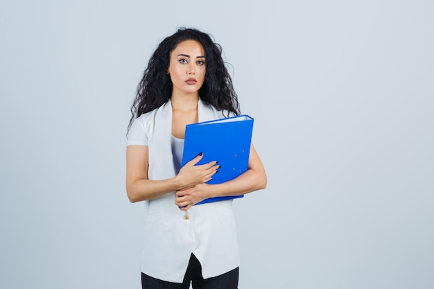 Joven empresaria sosteniendo una carpeta azul