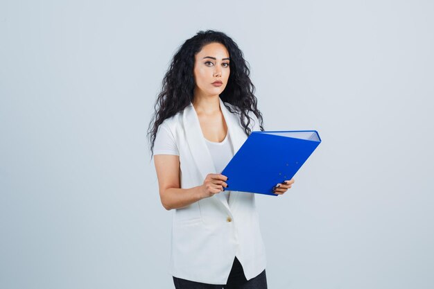 Joven empresaria sosteniendo una carpeta azul