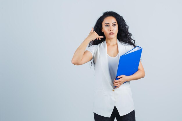 Joven empresaria sosteniendo una carpeta azul