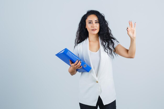 Joven empresaria sosteniendo una carpeta azul