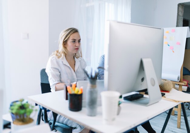 Foto gratuita joven empresaria trabajando en la computadora en la oficina