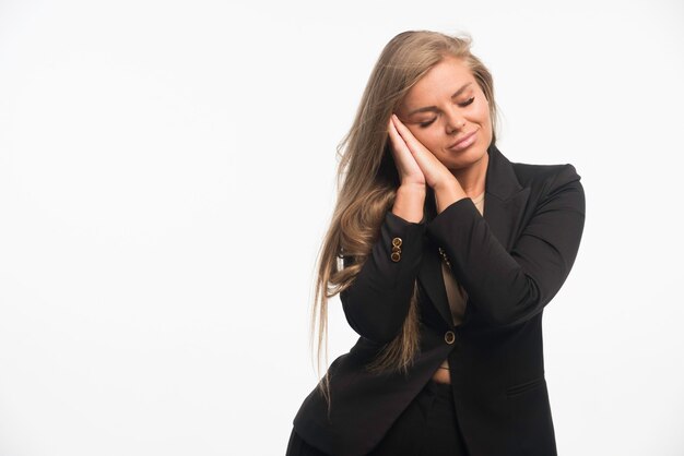 Joven empresaria en traje negro parece soñadora