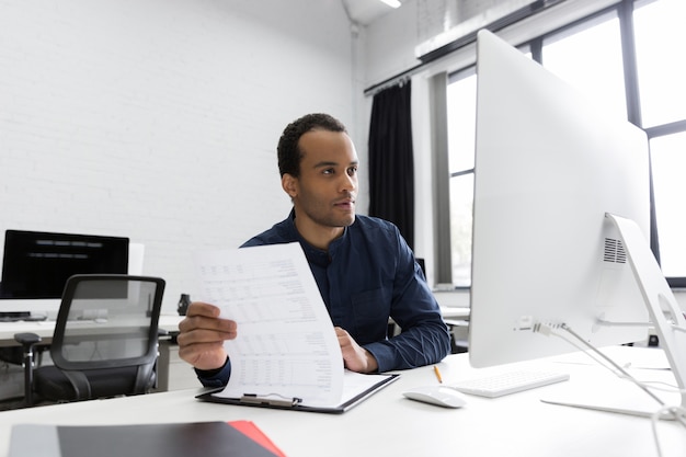 Joven empresario africano sentado en su escritorio