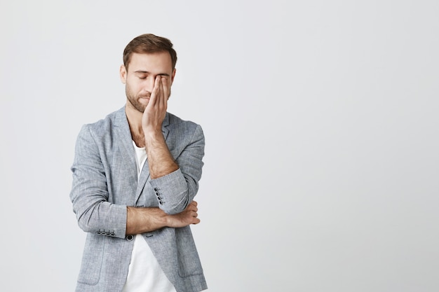 Joven empresario agotado frotar los ojos sentirse cansado