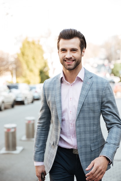 Joven empresario caminando al aire libre