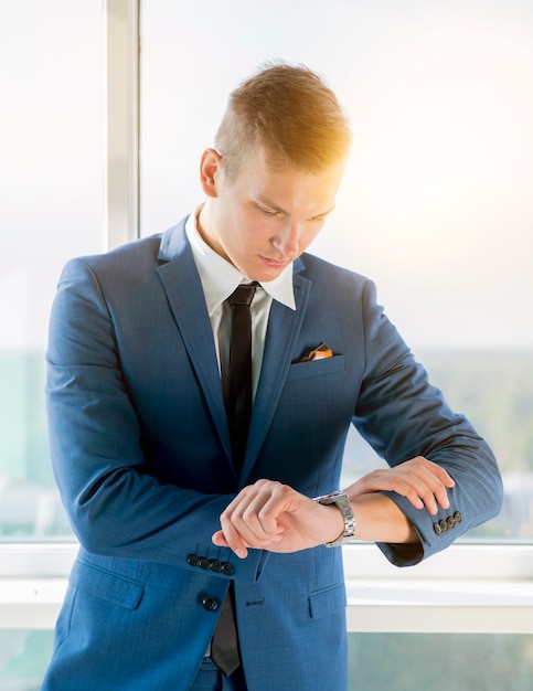 Foto gratuita joven empresario comprobando el tiempo en el reloj de pulsera