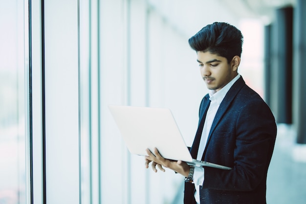 Joven empresario con computadora portátil trabajando en la oficina