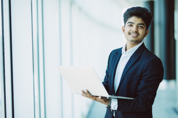 Joven empresario con computadora portátil trabajando en la oficina