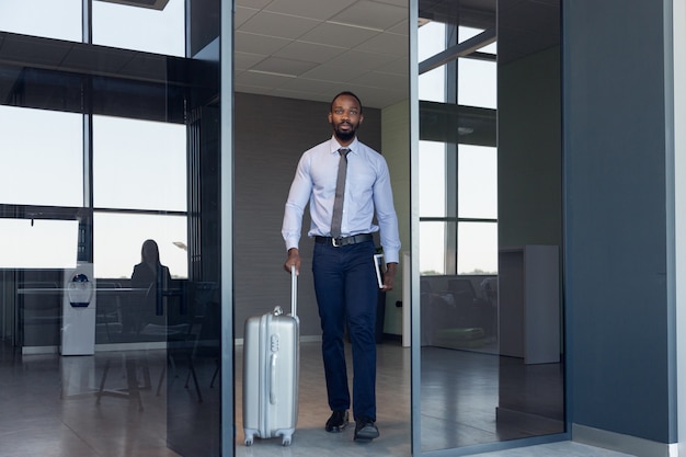 Joven empresario esperando la salida en el aeropuerto, viaje de trabajo, estilo de vida empresarial.