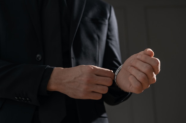 Joven empresario guapo en camisa negra y traje negro