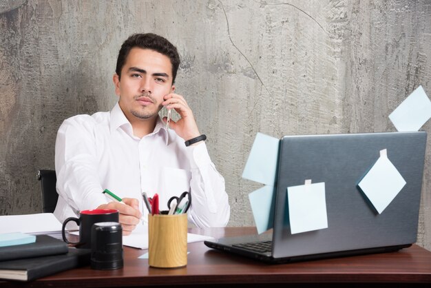 Joven empresario hablando de asuntos serios en el escritorio de la oficina.