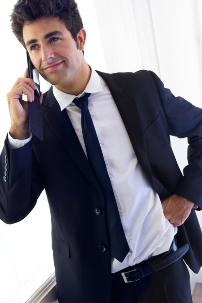 Joven empresario hablando con teléfono inteligente