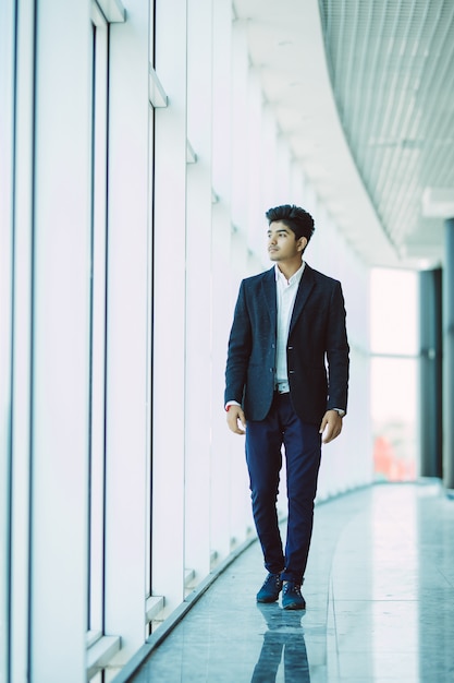 Joven empresario indio asiático caminando a la oficina en la mañana