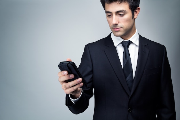 Joven empresario mirando smartphone