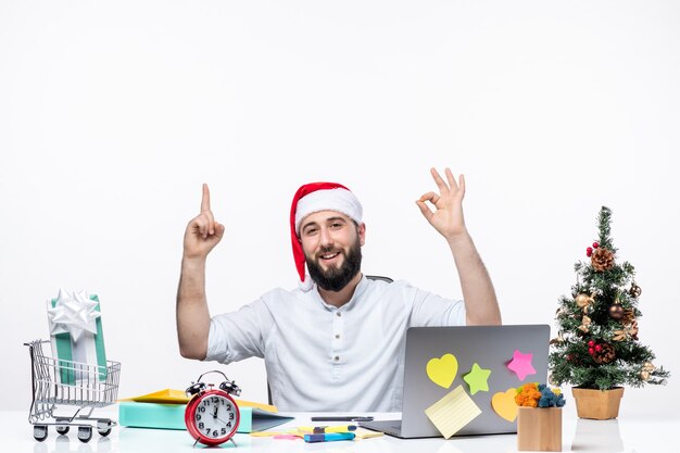 Joven empresario en la oficina celebrando apuntando hacia arriba haciendo gesto bien