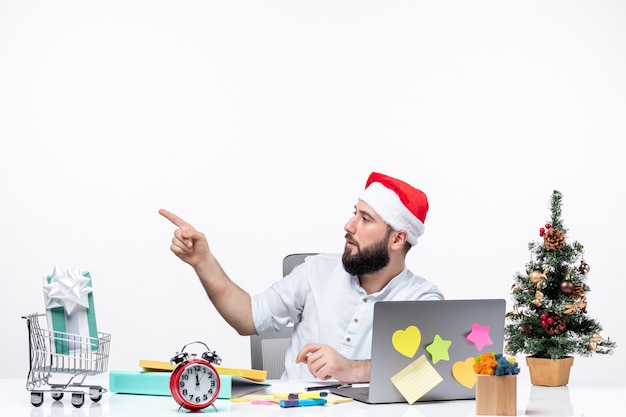 Joven empresario en la oficina celebrando la Navidad trabajando solo apuntando algo