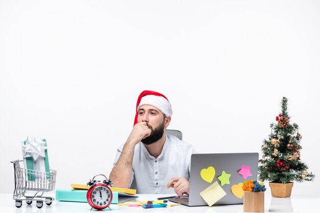 Joven empresario en la oficina celebrando la Navidad trabajando solo y centrado