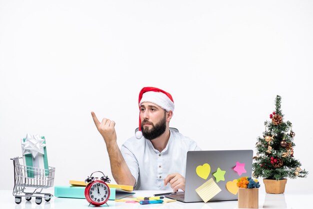 Joven empresario en la oficina celebrando la Navidad trabajando solo y llamando a alguien