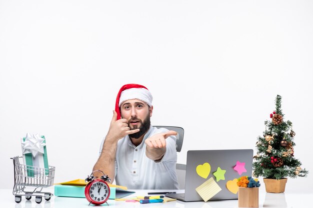 Joven empresario positivo con sombrero de santa claus trabajando