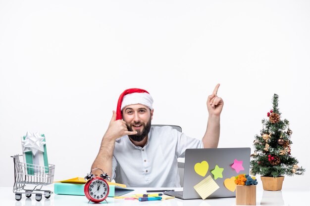 Joven empresario positivo con sombrero de santa claus trabajando