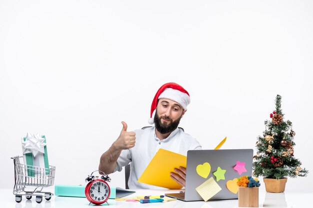 Joven empresario satisfecho en la oficina celebrando y sosteniendo documentos comprobando notas haciendo gesto ok