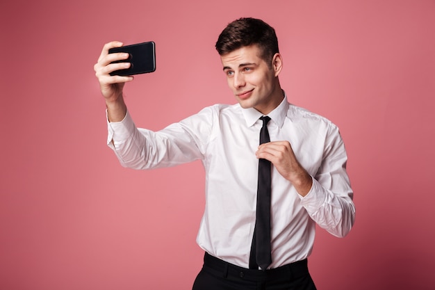 Joven empresario serio hacer selfie por teléfono móvil