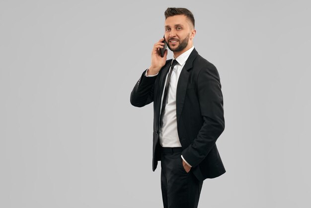 Joven empresario sonriente hablando por teléfono