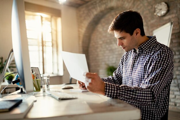 Joven empresario trabajando en informes comerciales en la oficina