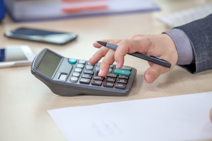 Foto gratuito joven empresario trabajando desde su oficina y calculando números