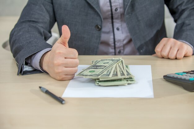 Joven empresario trabajando desde su oficina y contando dinero en efectivo