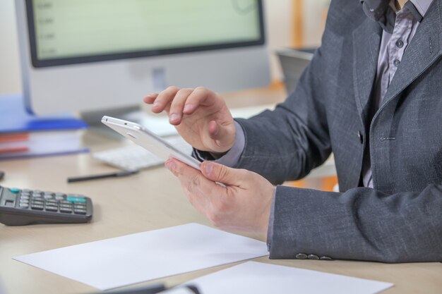 Joven empresario trabajando desde su oficina en su tableta