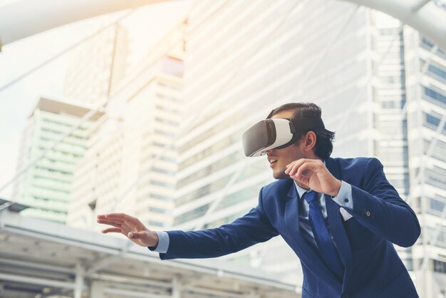 Joven empresario en traje negro llevaba gafas de realidad virtual.