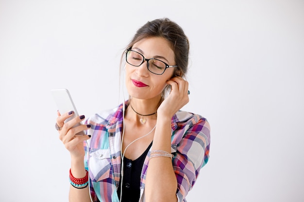 Joven encantadora con gafas disfrutando de la música